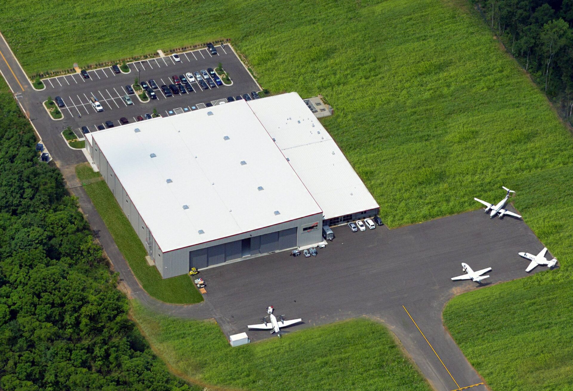 Aerial view of an airport apron and aviation hangar with parked aircraft