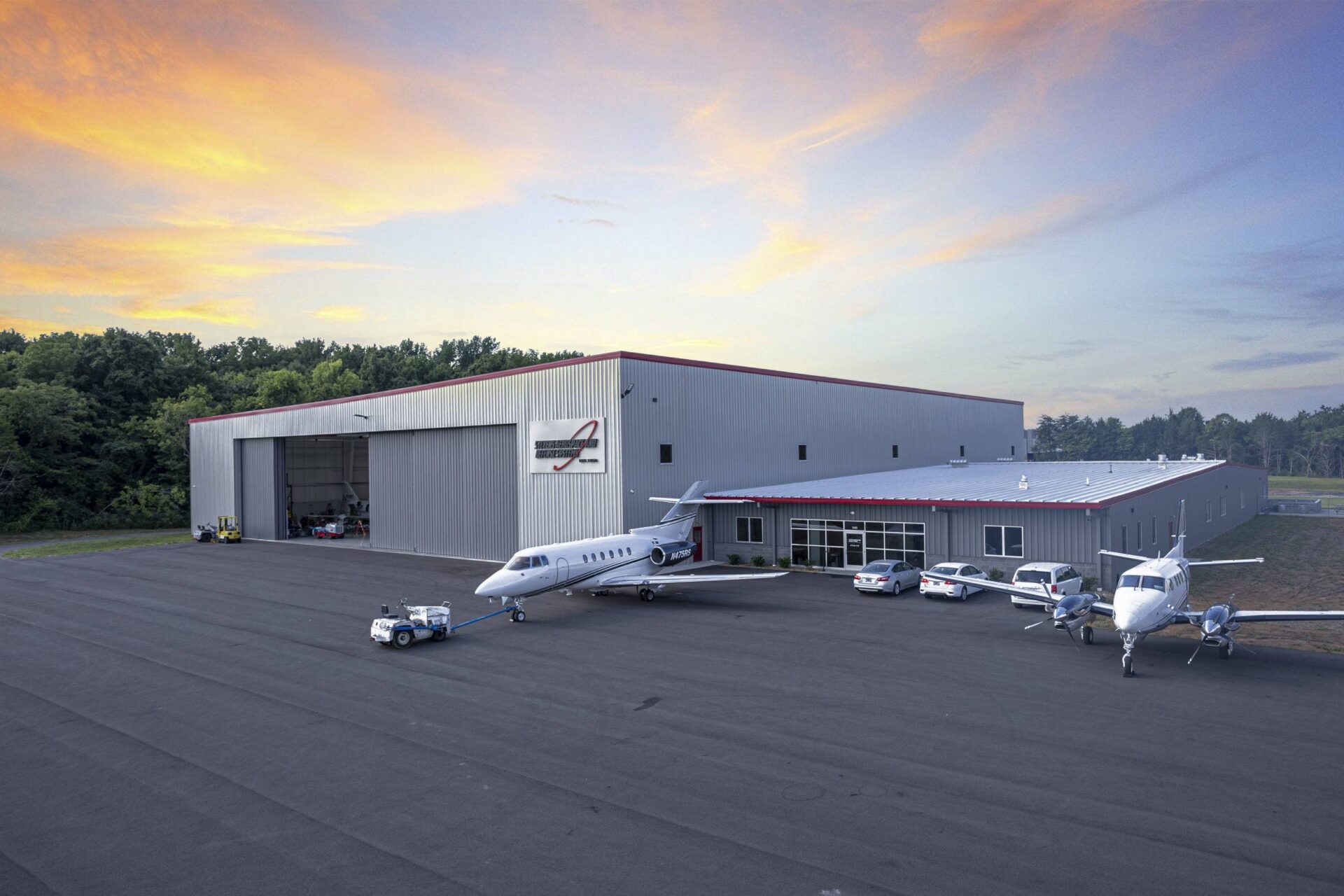Aerial view of an airport site and aviation hangar at sunset