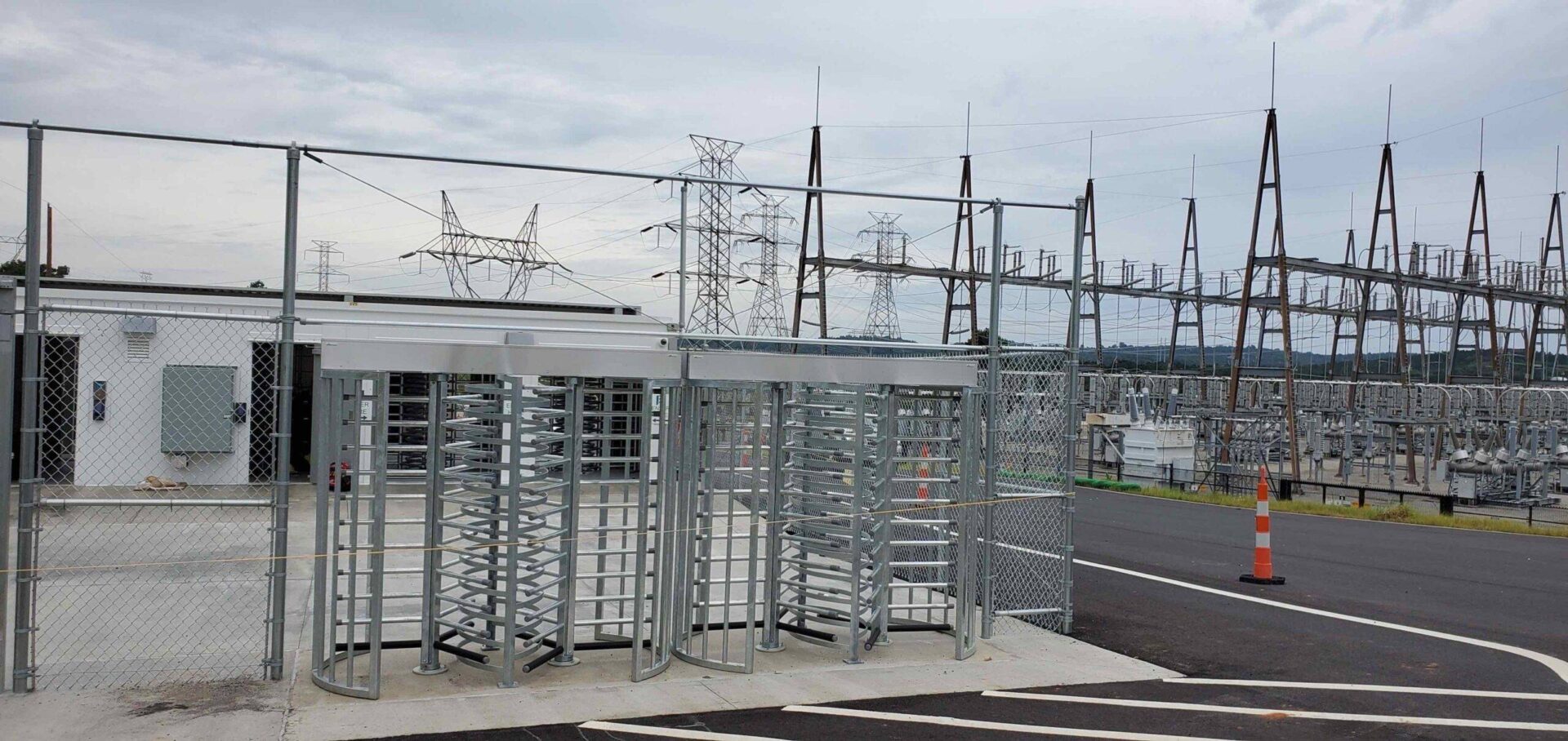 Full-height turnstiles and vehicle gate at a substation access control point