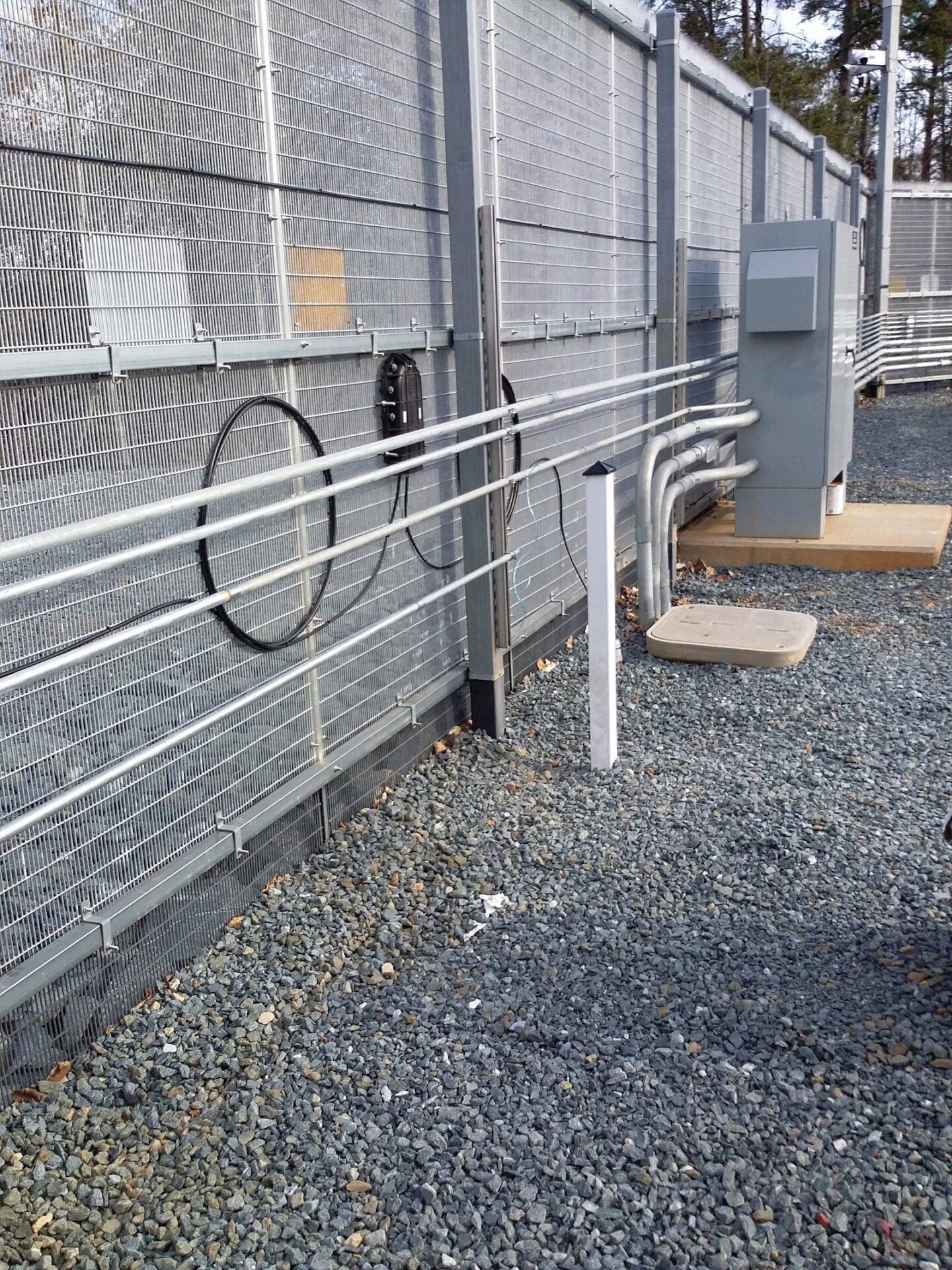 Conduit and cable pathways installed along a security fence